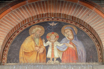 Holy Family, lunette over the portal of small church in Via Santa Maria  in Pisa, Italy © zatletic