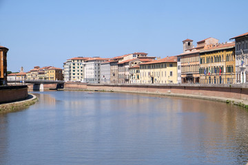 Fototapeta na wymiar River Arno floating through the medieval city of Pisa in Italy
