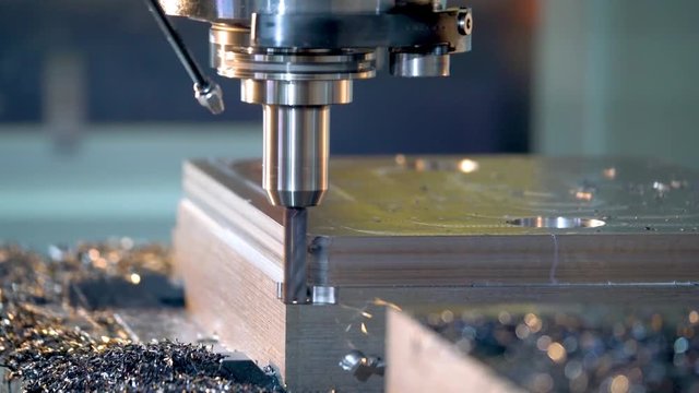 CNC milling machine cutting steel in a machine shop.