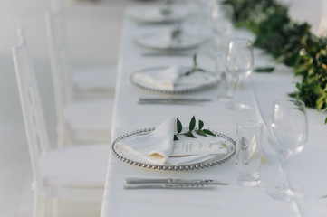 Classic white set of wedding dinner table. White bouquets as a centerpiece