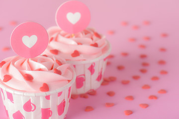 Tasty pink pastel butter cream cupcakes on red background, delicious butter cream cupcakes, Valentines cupcakes, hearts for Valentines, Valentines day card concept.