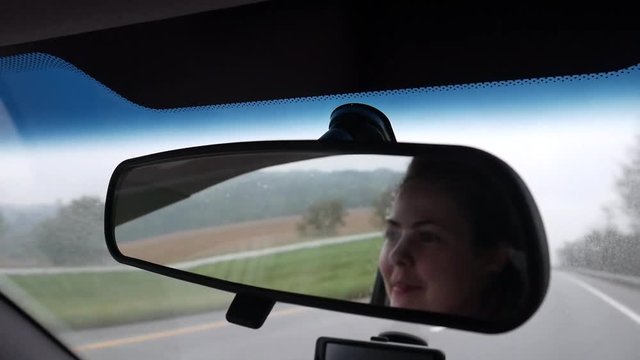 Woman Looking in Rearview Mirror of Car While Driving