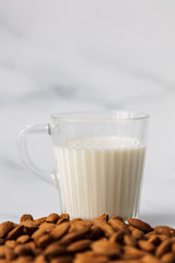 Almond milk in a glass surrounded by organic almonds