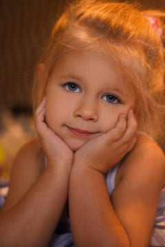 Little girl smiling and playing in bed, evening