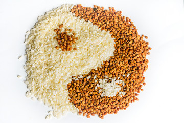 The symbol of yin yang is laid out of buckwheat and rice, texture.