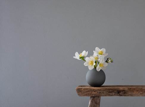 Kleine Vase mit wei&szlig;en Blumen auf Holzhocker
