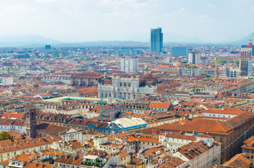 Fototapeta na wymiar Aerial top panoramic view of Turin city historical centre, Palazzo Carignano palace, orange tiled roofs of buildings, sightseeings and skyscrapers with Alps mountain range, Torino, Piedmont, Italy