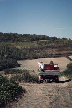 Man sitting on the back of a farm truck
