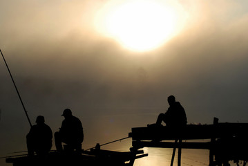 Fototapeta na wymiar silhouette of fisherman at sunset