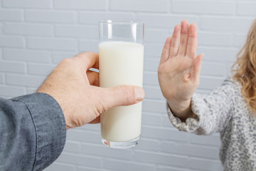 hand rejecting the glass of milk, intolerance to dairy