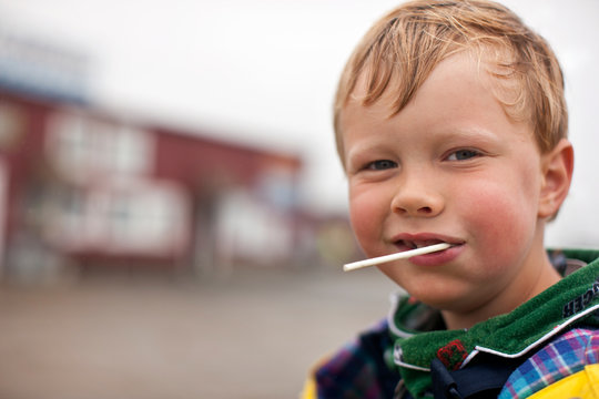 Portrait of young boy sucking on a lollipop.