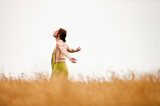 Teenage girl spinning in the wheat field.