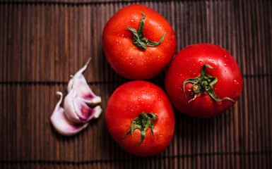 tomatoes on a bamboo board. Juicy vegetables on a brown background