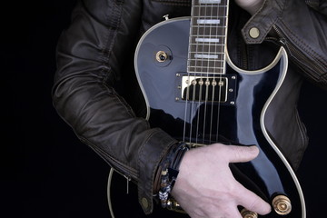 Guitarist.Closeup of electrical guitar fingerboard.Hand of rocker in leather  bracelet.Rock & roll, heavy metal,gothic,punk,horns sign and fist.Hard style.Rivets accessories