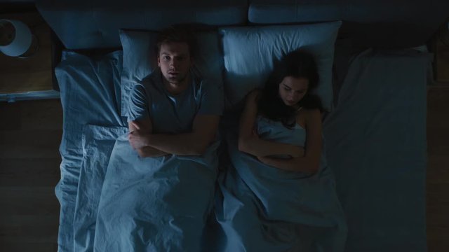 Quarrelling Young Couple in the Bed, Young People in a Row Turn Away From Each other and Lay on Their Sides Holding Grudges and Being Offended.