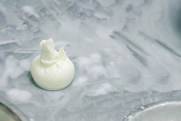 The process of making burrata cheese on a metal table in a cheese factory