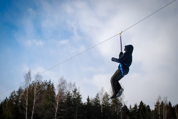 Winter games on the frozen river. Zip-line