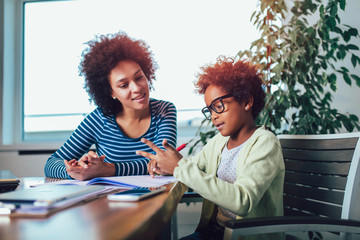 Mother and daughter doing homework learning to calculate