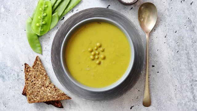Green pea cream soup in grey bowl