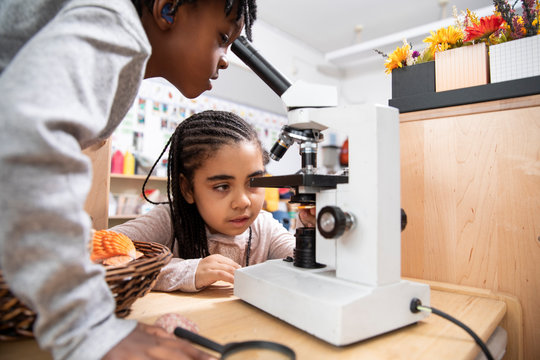 Students using microscope in classroom