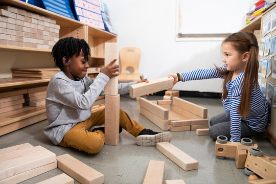 Boy and girl playing with wooden blocks