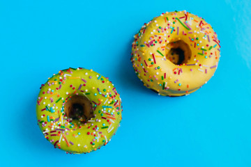 Two color donuts. Yellow and Green Donut on a blue background. Dessert