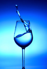A splash of water in a glass. White-blue lights in the center and deep blue at the edges.