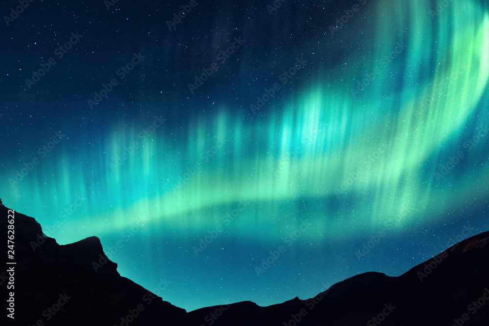 Wall mural aurora borealis. northern lights in winter mountains. sky with polar lights and stars
