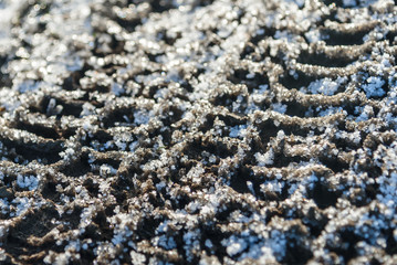 The track from the tread of the car close-up on the icy road.