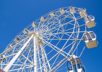 Close-up of a ferris wheel against a blue sky