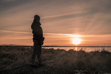 woman watches the sun setting 