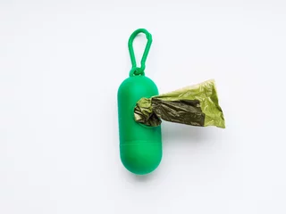 Compostable dog poop bags dispenser on white © tenkende