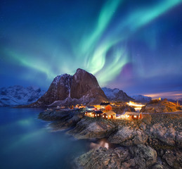Aurora borealis on the Lofoten islands, Norway. Green northern lights above ocean. Night sky with polar lights. Night winter landscape with aurora and reflection on the water surface. Norway-image - obrazy, fototapety, plakaty