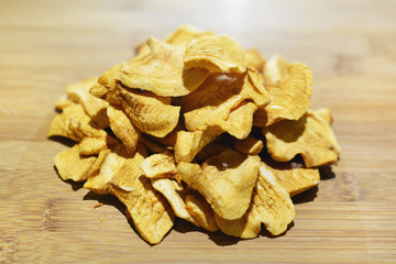 Sliced dried homemade apple chips on a wooden table