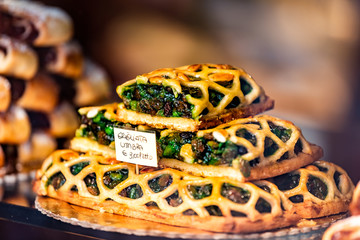 Colorful green baked lattice pastry tart dessert closeup in store window in Assisi in Umbria Italy on display in gourmet bakery Italian cafe with sign - obrazy, fototapety, plakaty