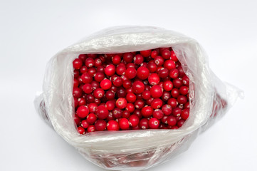 Wild berries cranberries in a bag on a white background top view.