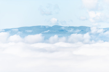 Mountain mist fog sunrise in Umbria and Tuscany in Italy with soft clouds covering blanketing inversion in summer