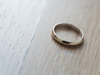 Closeup shot of a silver wedding ring on wooden background