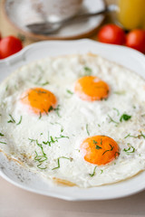 Fried egg. Close up view of the fried egg on a white plate. Light morning Breakfast, fresh warm pastries and aromatic cappuccino coffee