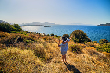 Beautiful woman in beach hat enjoying sea view with blue sky at sunny day in Bodrum, Turkey. Vacation Outdoors Seascape Summer Travel Concept