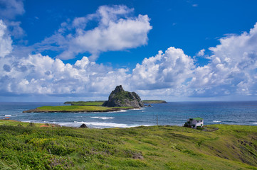 Landscape view of a cloudy day, with a house at background