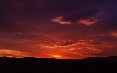 Sunset mountain peaks sky panorama. Mountain peaks sunset view. Sunset mountain peaks silhouette. Mountain sunset sky clouds