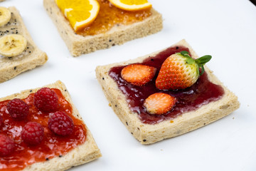 Delicious colourful minimal mix fruits jam on sliced bread. Set on white background.