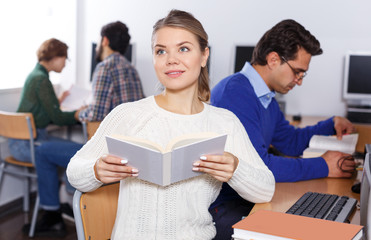 Fototapeta premium female student reading textbook while studying