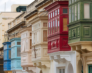 Street with colourful traditional wooden maltese balconies in Sliema, Malta