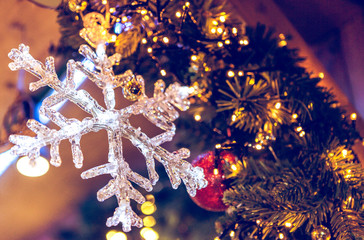 Very beautiful transparant snowflake next to the Cristmas Tree and light decorations.