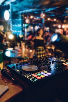 DJ Plays Live Set And Mixing Music On Turntable Console At Stage In The Night Club. Disc Jokey Hands On A Sound Mixer Station At Club Party. DJ Mixer Controller Panel For Playing Music And Partying.