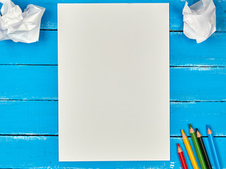blank white rectangular sheet of paper and crumpled pieces of paper