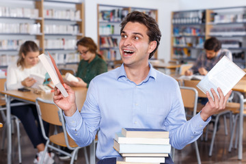 Portrait of delighted man with books