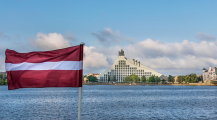 the Latvian flag in the foreground, with the national library and the river Daugava in the background, Riga.